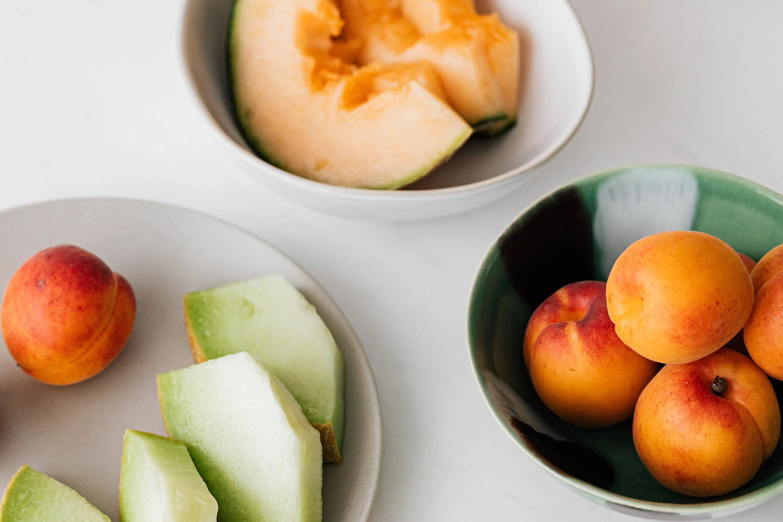 three bowls of cut fruit